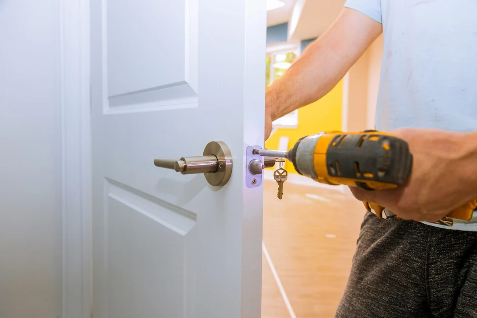 Lock hardware being fitted to a white residential door